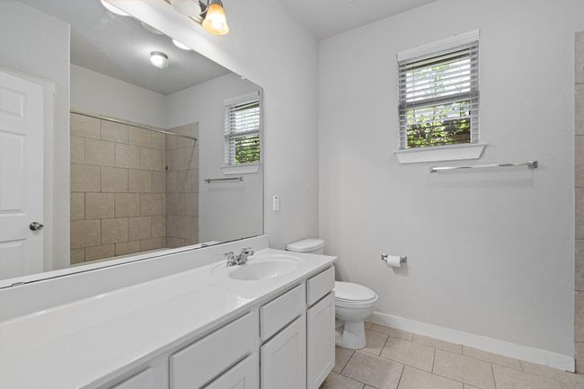 Bathroom with plenty of natural light, vanity, tiled shower, and tile patterned floors | Image 33