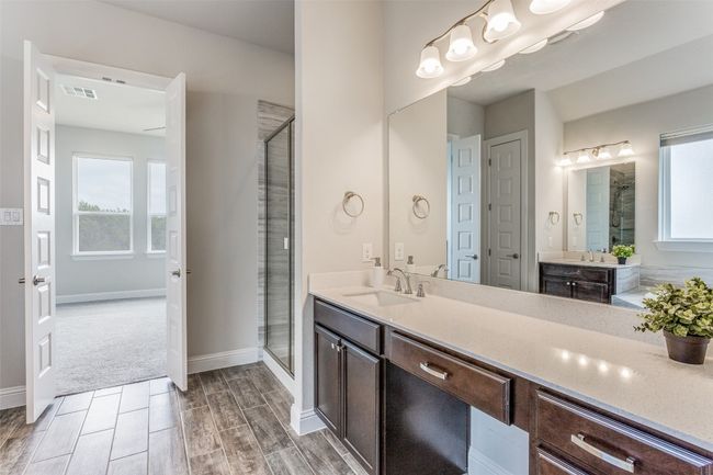 Bathroom with plenty of natural light, a stall shower, and vanity | Image 11