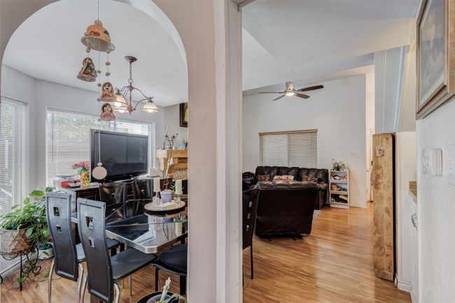 Dining room with arched walkways, light wood-style floors, and ceiling fan | Image 13