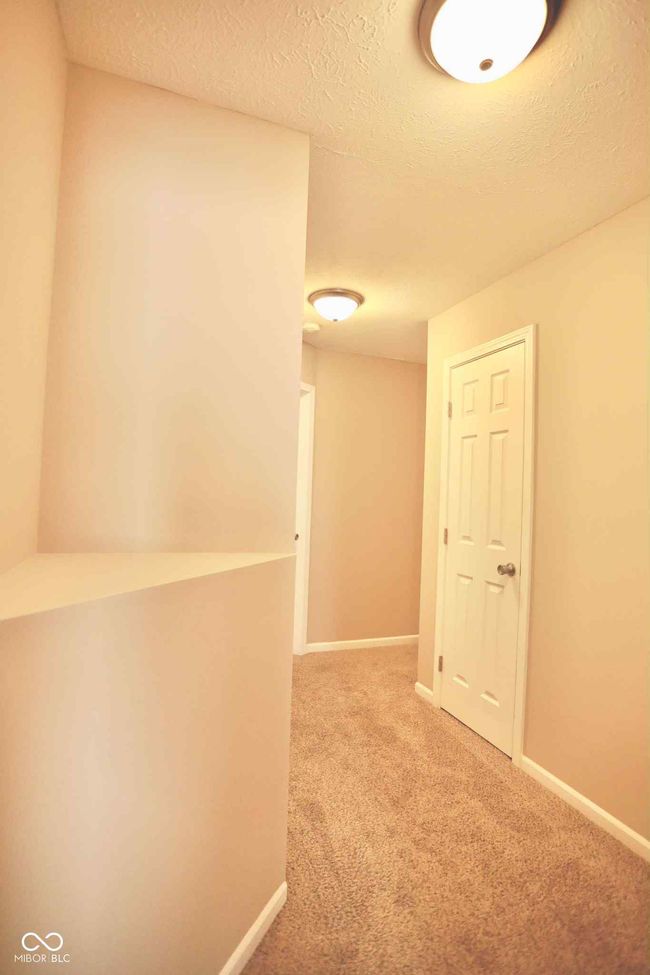 hall featuring a textured ceiling, baseboards, and carpet floors | Image 27