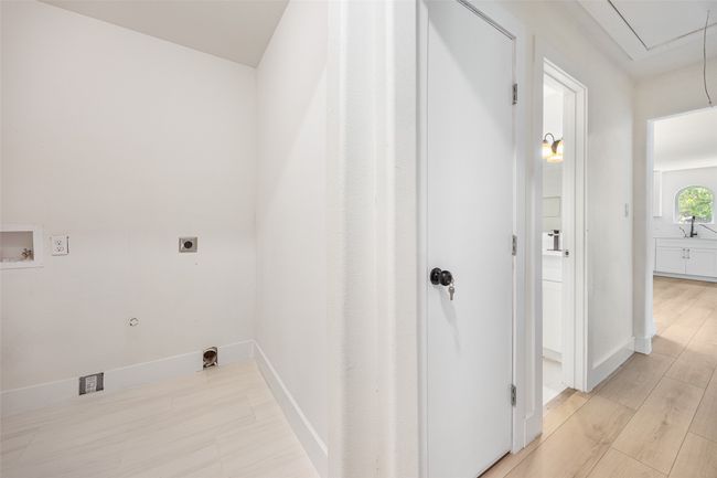 Laundry room featuring attic access, gas dryer hookup, hookup for a washing machine, light wood-type flooring, and electric dryer hookup | Image 13