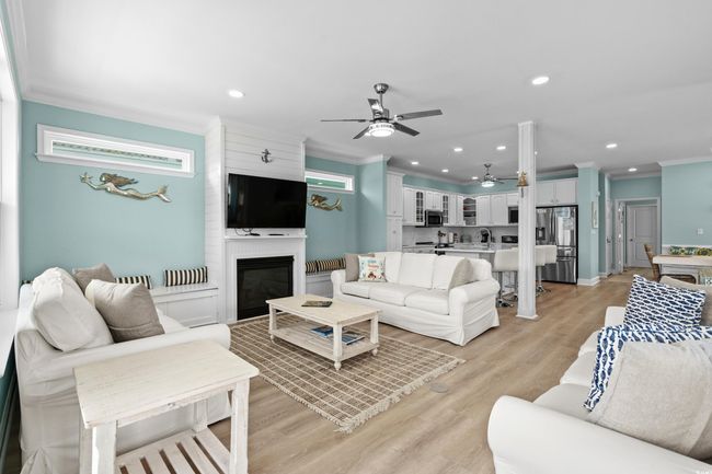 Living room featuring crown molding, light wood-style floors, a large fireplace, a ceiling fan, and recessed lighting | Image 5
