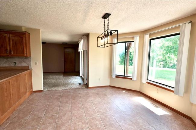Unfurnished dining area featuring light tile patterned floors and a textured ceiling | Image 15