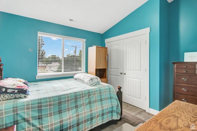 Carpeted bedroom with vaulted ceiling and a closet | Image 24