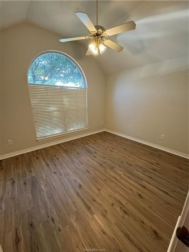 Spare room featuring lofted ceiling, wood finished floors, and ceiling fan | Image 9