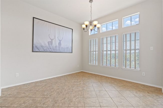 Unfurnished room featuring baseboards, light tile patterned floors, and a chandelier | Image 25