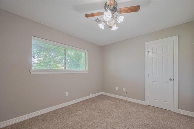 2nd bedroom offers natural lighting from a large window, fan, and ample-sized closet | Image 17