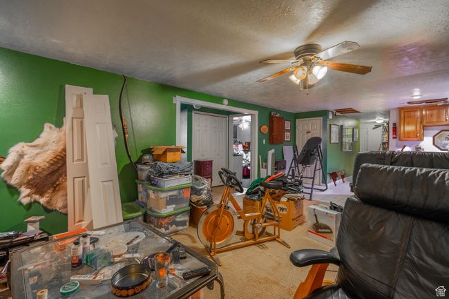 Carpeted living area with a textured ceiling and a ceiling fan | Image 50