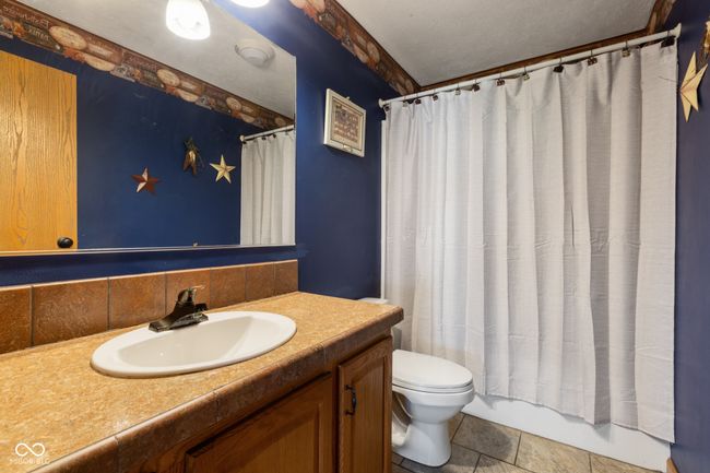 full bath with toilet, a textured ceiling, vanity, and a shower with shower curtain | Image 29