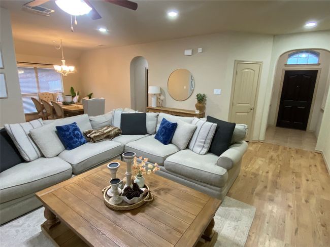Living room featuring recessed lighting, visible vents, arched walkways, light wood-style floors, and ceiling fan with notable chandelier | Image 15