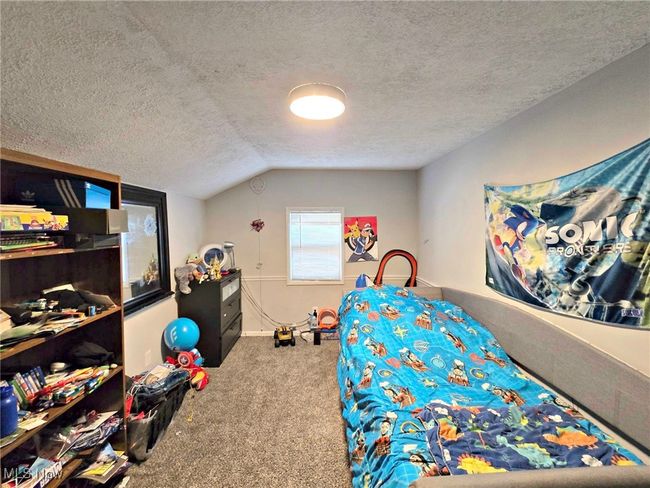 Bedroom featuring carpet floors, a textured ceiling, and vaulted ceiling | Image 39