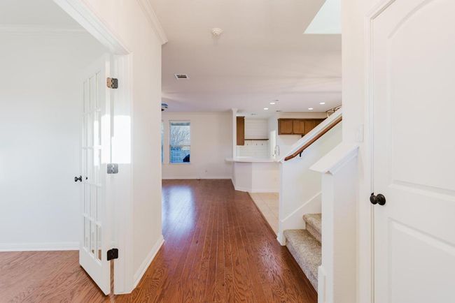 Corridor with visible vents, baseboards, light wood-style flooring, and stairs | Image 5