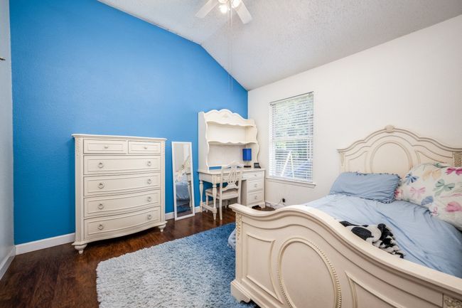 Bedroom with lofted ceiling, dark wood-style flooring, ceiling fan, and a textured ceiling | Image 13