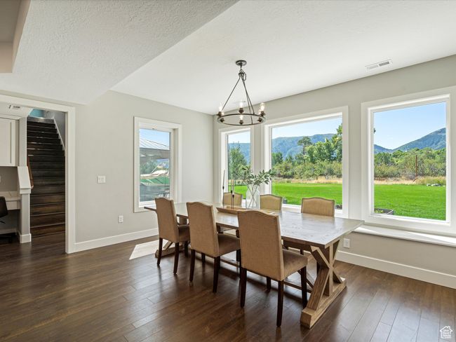 Dining room with a chandelier, baseboards, dark wood-style flooring, a mountain view, and stairway | Image 14