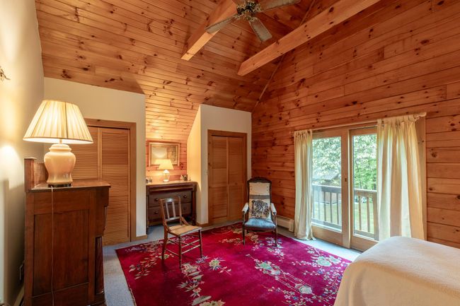 Carpeted bedroom with access to outside, wooden ceiling, wood walls, and a baseboard heating unit | Image 21