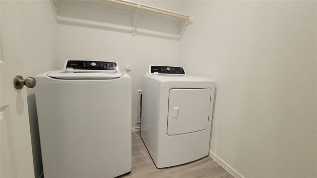 Washroom featuring washer and clothes dryer and light wood-style flooring | Image 11