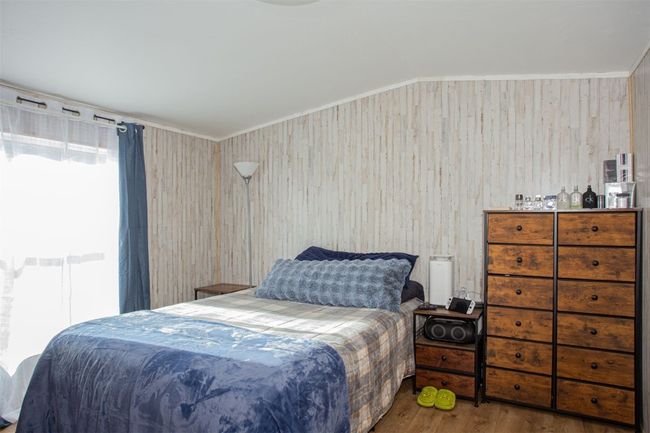 Bedroom with hardwood / wood-style flooring and wood walls | Image 8