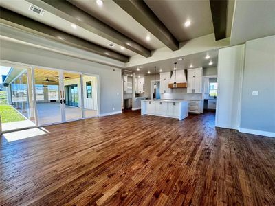 Unfurnished living room featuring dark hardwood / wood-style flooring and beamed ceiling | Image 2