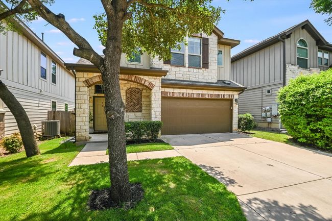 Multi unit property with stone siding, an attached garage, concrete driveway, and central AC | Image 9
