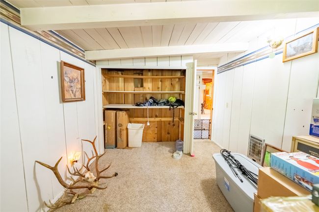 Below grade area featuring carpet floors, heating unit, and wooden walls | Image 34