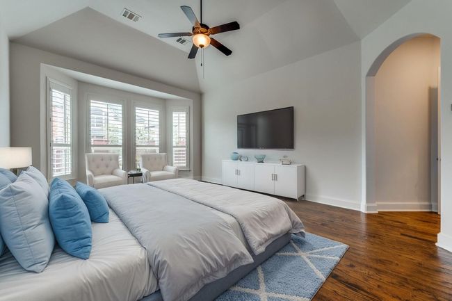 Bedroom with arched walkways, multiple windows, dark wood-type flooring, and baseboards | Image 8