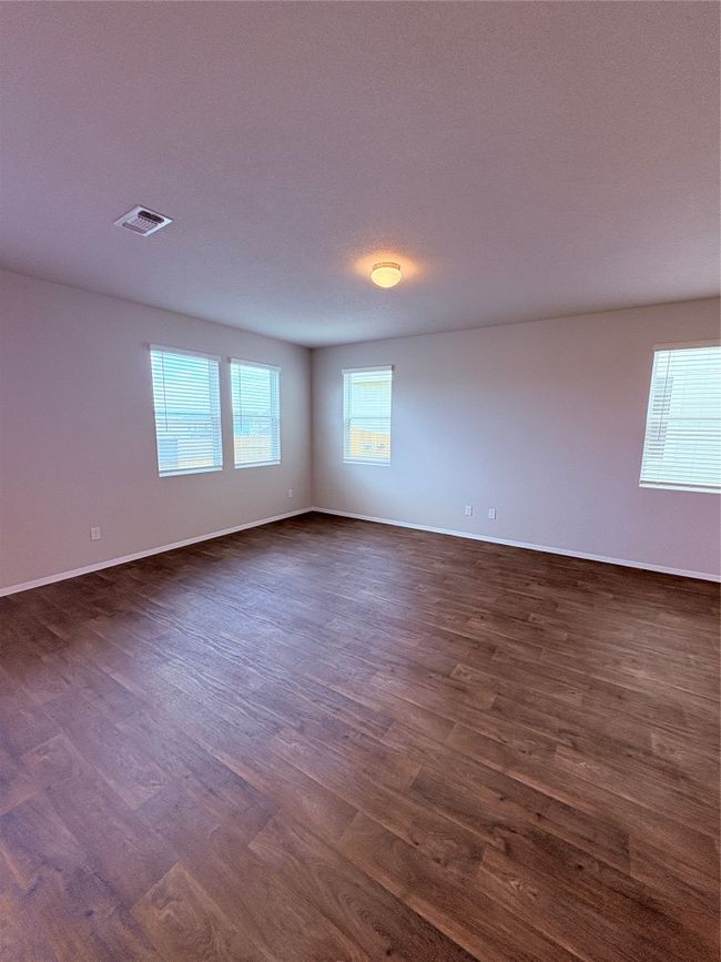 Spare room with dark wood-style floors, baseboards, and visible vents | Image 4