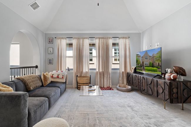 Carpeted living room featuring baseboards and high vaulted ceiling | Image 11