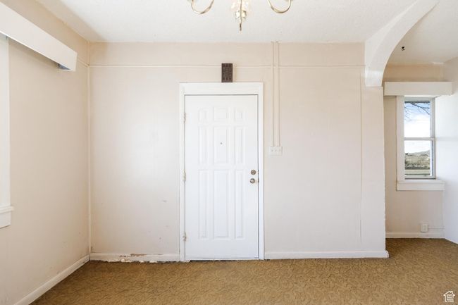 Empty room with light carpet and arched walkways | Image 8