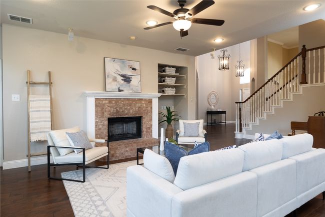 Living area with built in shelves, ceiling fan, a fireplace, wood finished floors, and recessed lighting | Image 10