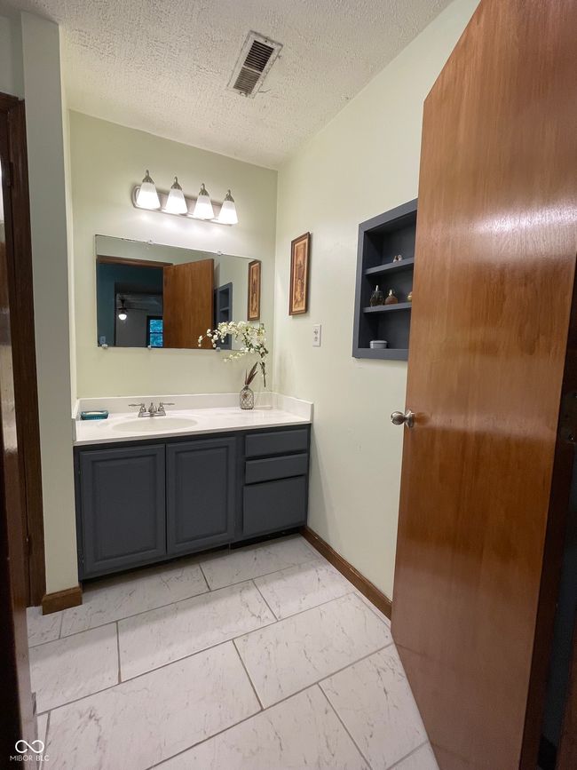 bathroom featuring double vanity, marble finish floors, and a textured ceiling | Image 4