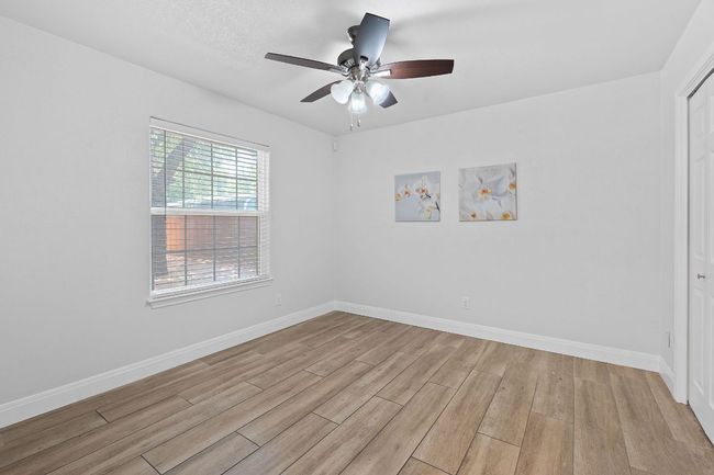Empty room with light wood finished floors and a ceiling fan | Image 15