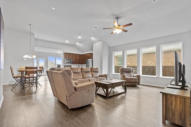 Living room with a ceiling fan, lofted ceiling, and wood finished floors. | Image 11
