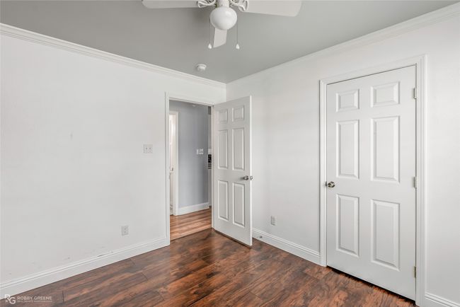 Unfurnished bedroom featuring ornamental molding, dark wood-style flooring, ceiling fan, and baseboards | Image 11