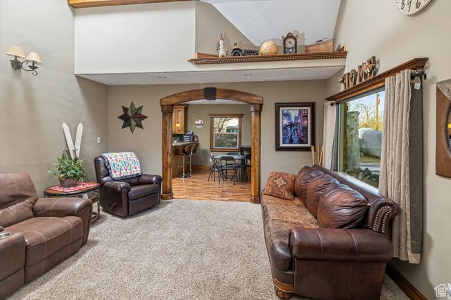Carpeted living room featuring a high ceiling | Image 8