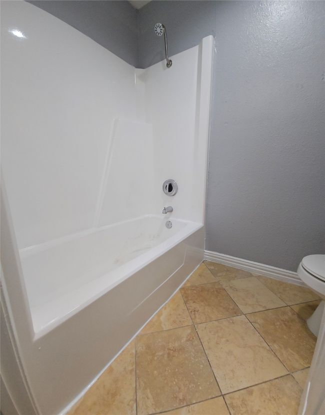 Full bathroom with washtub / shower combination and tile patterned floors | Image 12