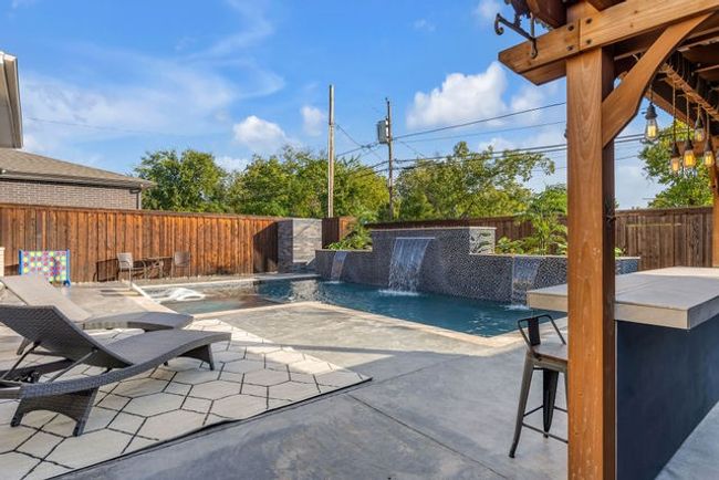 View of pool featuring a bar, pool water feature, and a patio area | Image 18