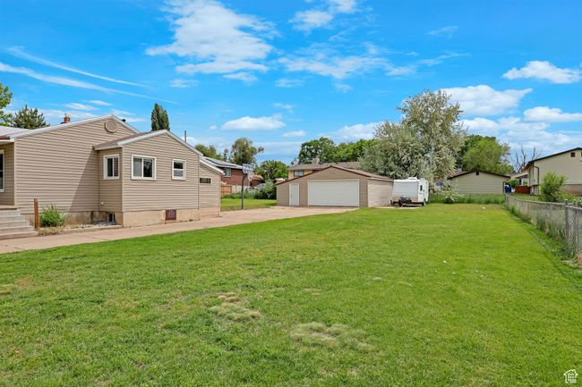 View of yard with a detached garage, an outdoor structure, and a residential view | Image 32
