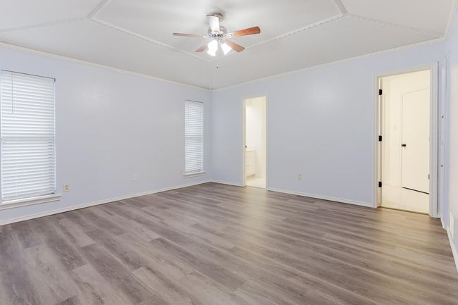 Spare room featuring wood finished floors, ornamental molding, lofted ceiling, and ceiling fan | Image 15