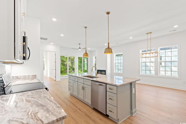 Kitchen with stainless steel appliances, gray cabinets, light wood-style floors, healthy amount of natural light, and recessed lighting | Image 8