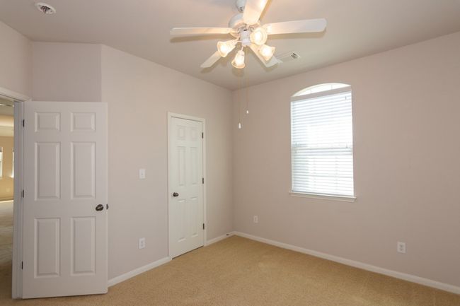 Unfurnished bedroom featuring visible vents, light colored carpet, baseboards, and ceiling fan | Image 19
