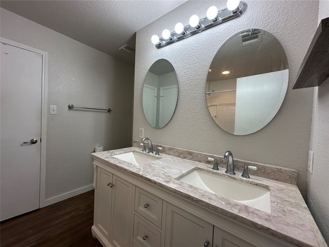 Full bathroom with wood finished floors, double vanity, and a textured ceiling | Image 33