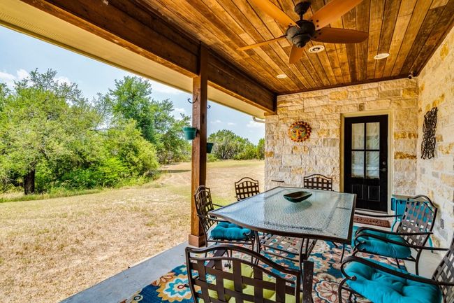 View of patio with a ceiling fan and outdoor dining area | Image 29