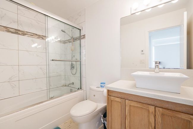 Full bathroom featuring toilet, vanity, and combined bath / shower with glass door | Image 24