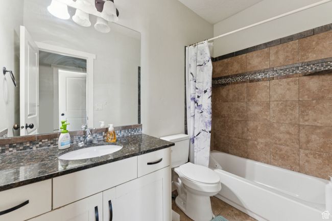 Full bath with vanity, toilet, tile patterned flooring, and shower / tub combo | Image 17