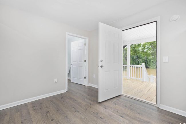 Empty room with wood finished floors, baseboards, and a smoke detector | Image 20