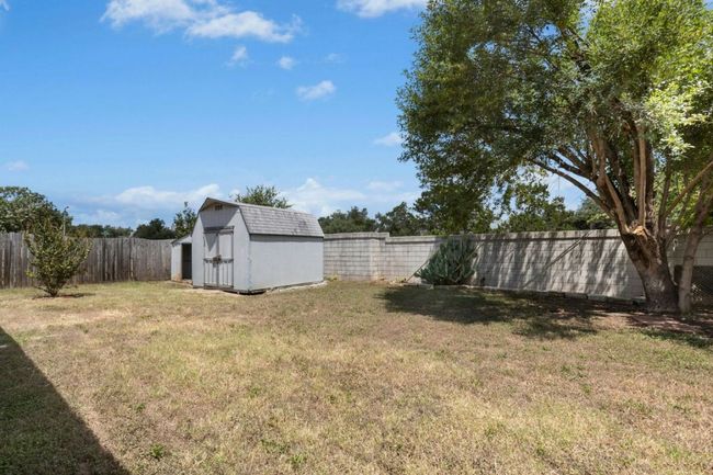 Fenced backyard with a shed | Image 32