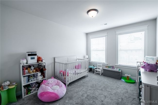 Carpeted bedroom with a crib | Image 24