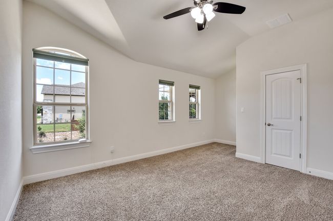 Unfurnished room featuring lofted ceiling, healthy amount of natural light, carpet, and a ceiling fan | Image 34