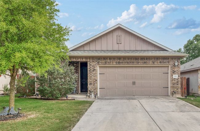 Single story home with brick siding, board and batten siding, driveway, a front lawn, and an attached garage | Image 30