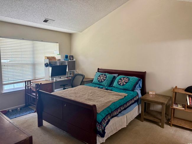 Bedroom featuring carpet, an office area, and a textured ceiling | Image 9